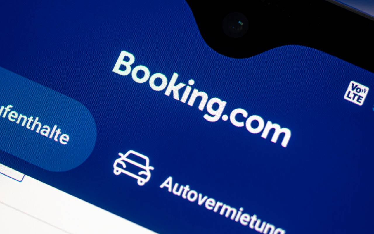 Auf einem Smartphone ist die App des Reiseportals Booking.com zu sehen.