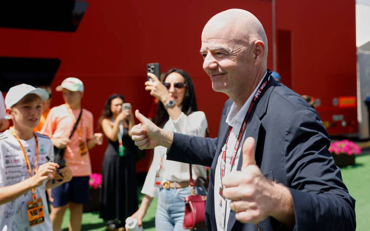 Gianni Infantino, Präsident der FIFA, schaut lächelnd und mit gestrecktem Daumen in Kameras.