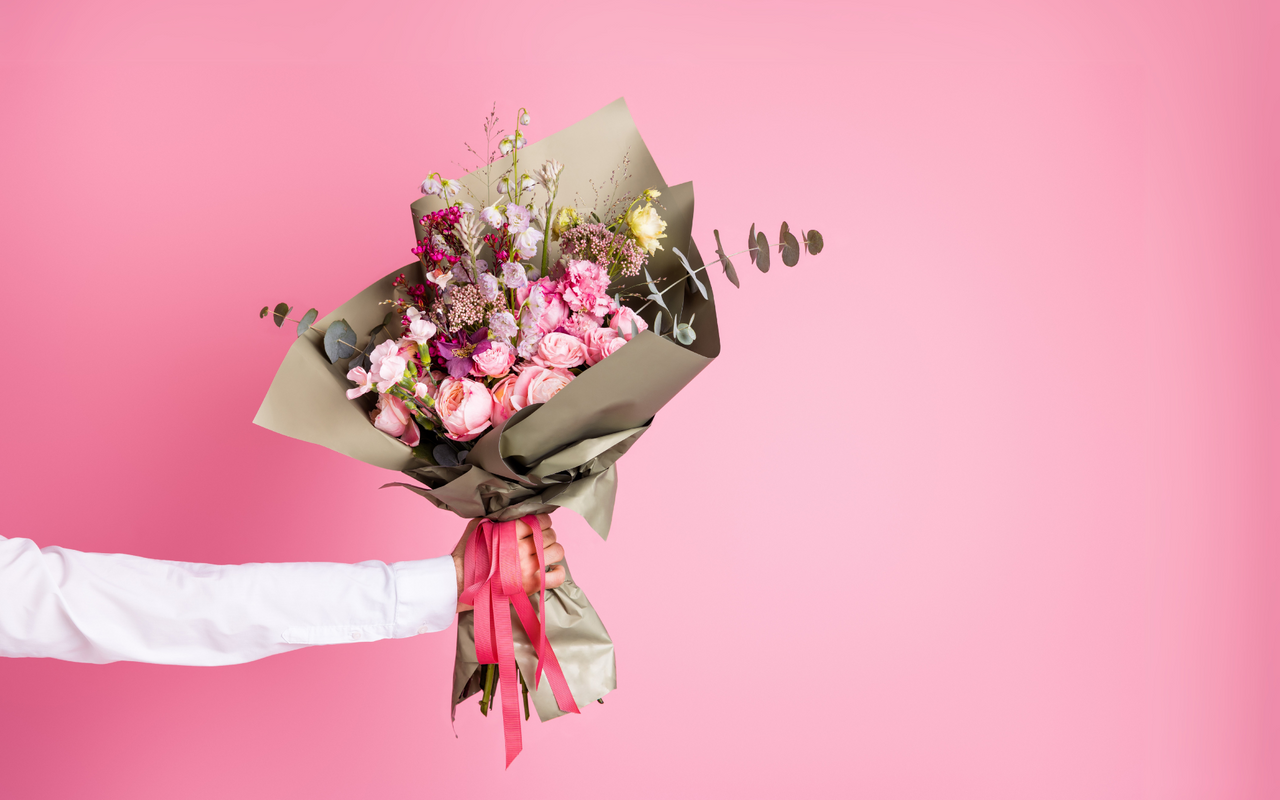 ein fröhlicher Blumenstrauß zum Valentinstag mit rosa Hintergrund