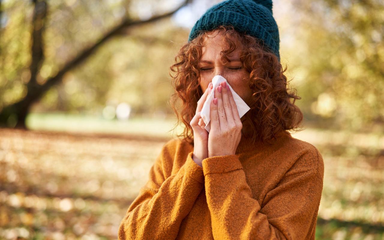 Fit durch den Herbst - Frau beim Naseputzen
