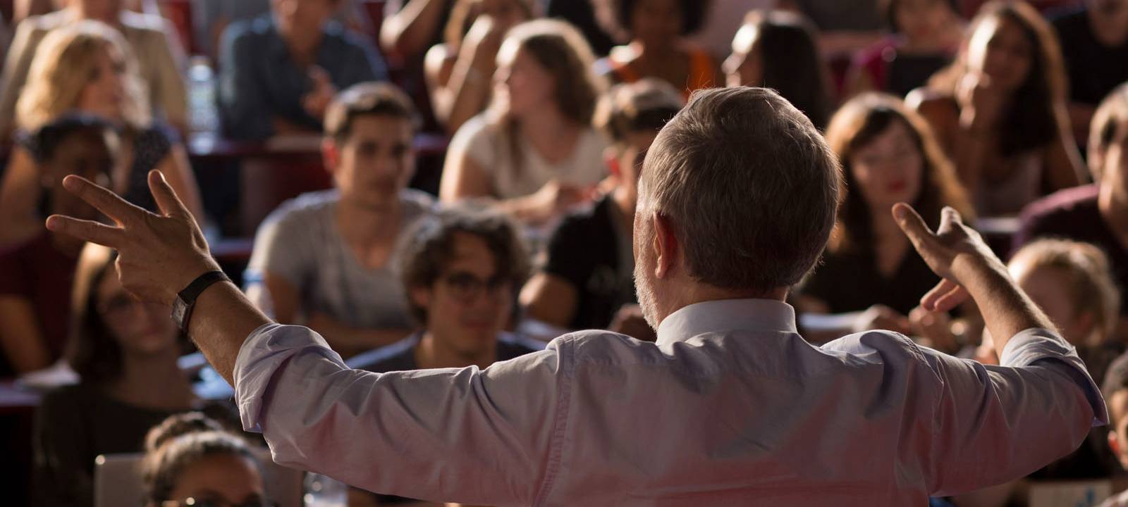 Alain hält eine Rede vor Managern.