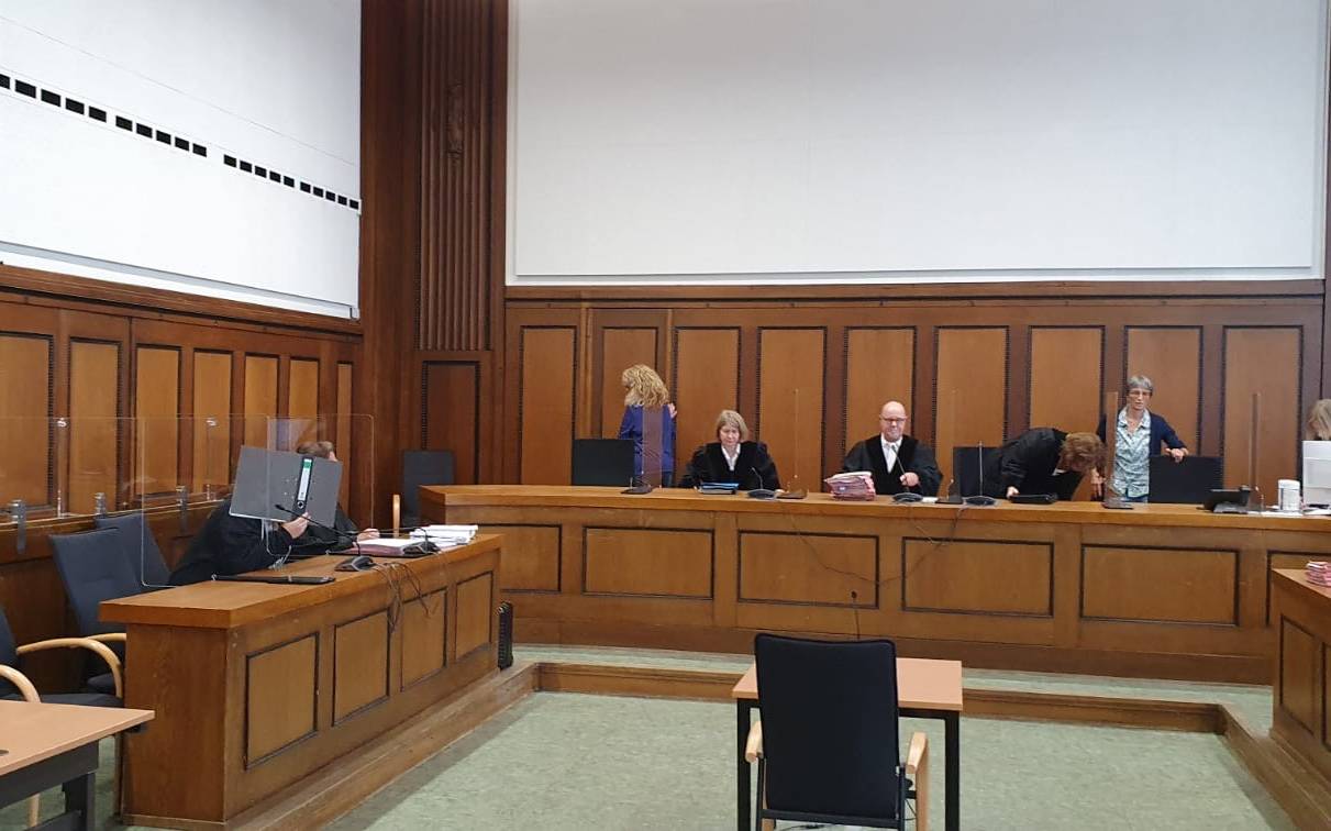 Prozess vor dem Landgericht Mönchengladbach. Die Angeklagte versteckt sich hinter einem Aktenordner.