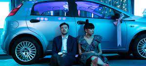 Katie und Stefan vor einem Auto.