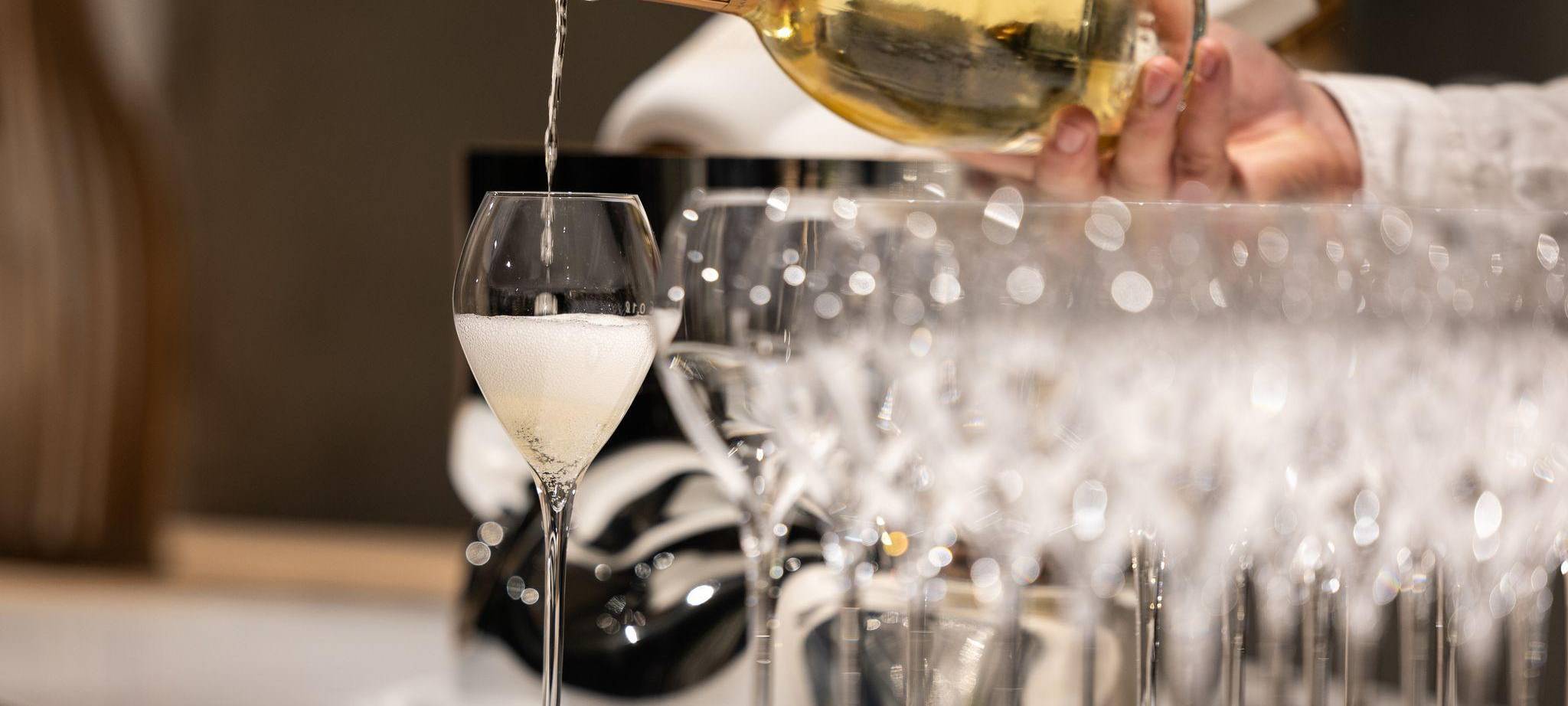 Kellner schenkt ein Glas Champagner ein