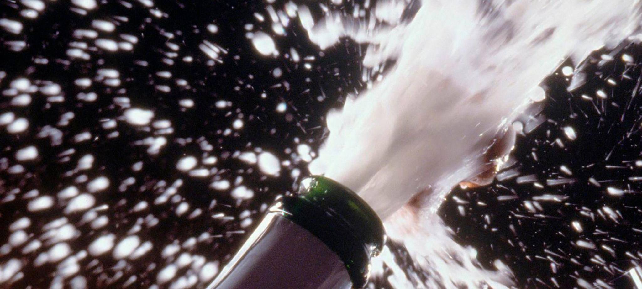 Sekt spritzt aus einer Flasche