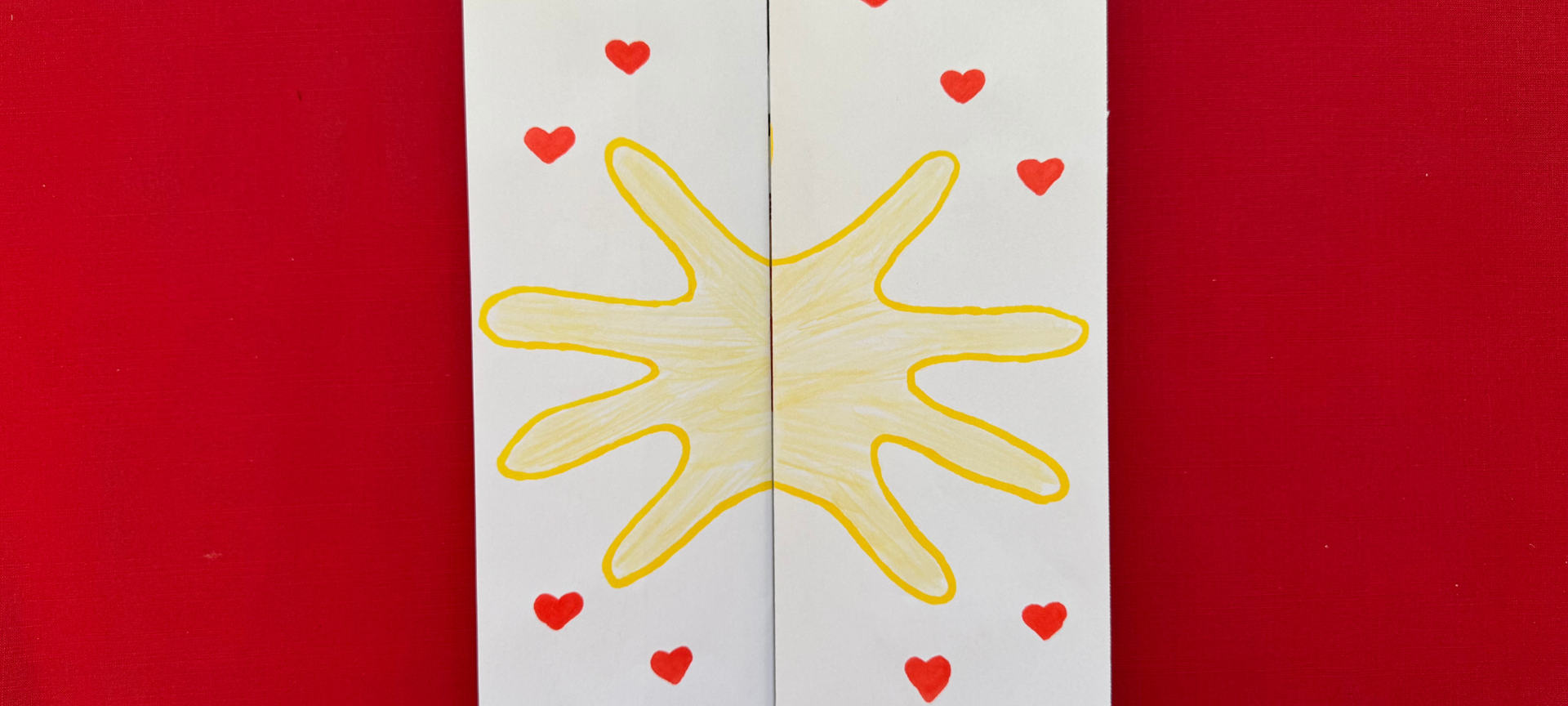 Hände des Kindes wie auf dem Foto abgebildet abmalen oder einen Handabdruck mit Hilfe von Acryl- oder Wasserfarbe machen